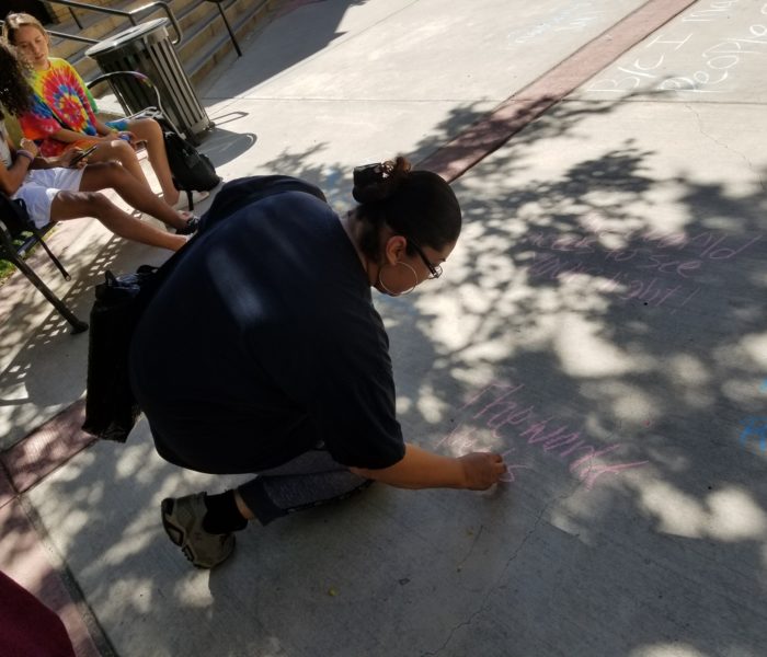 person writing on the sidewalk