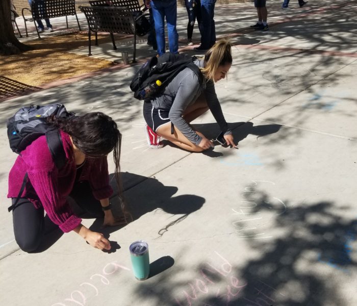 people writing on the sidewalk