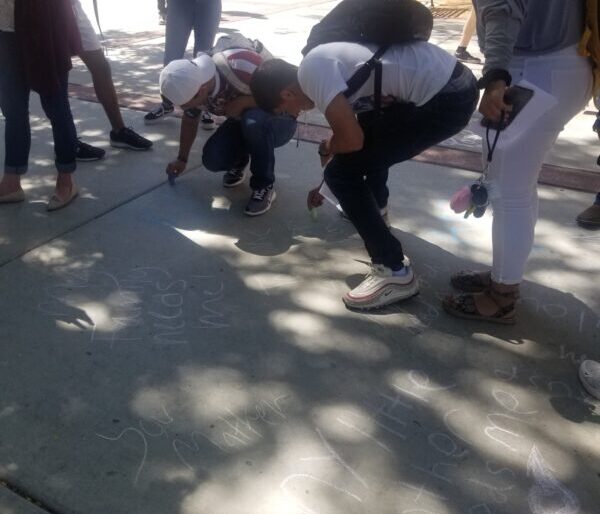 people writing on the sidewalk